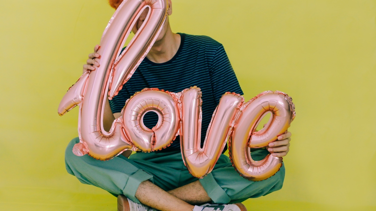 Мужчина держит шарики с надписью любовь