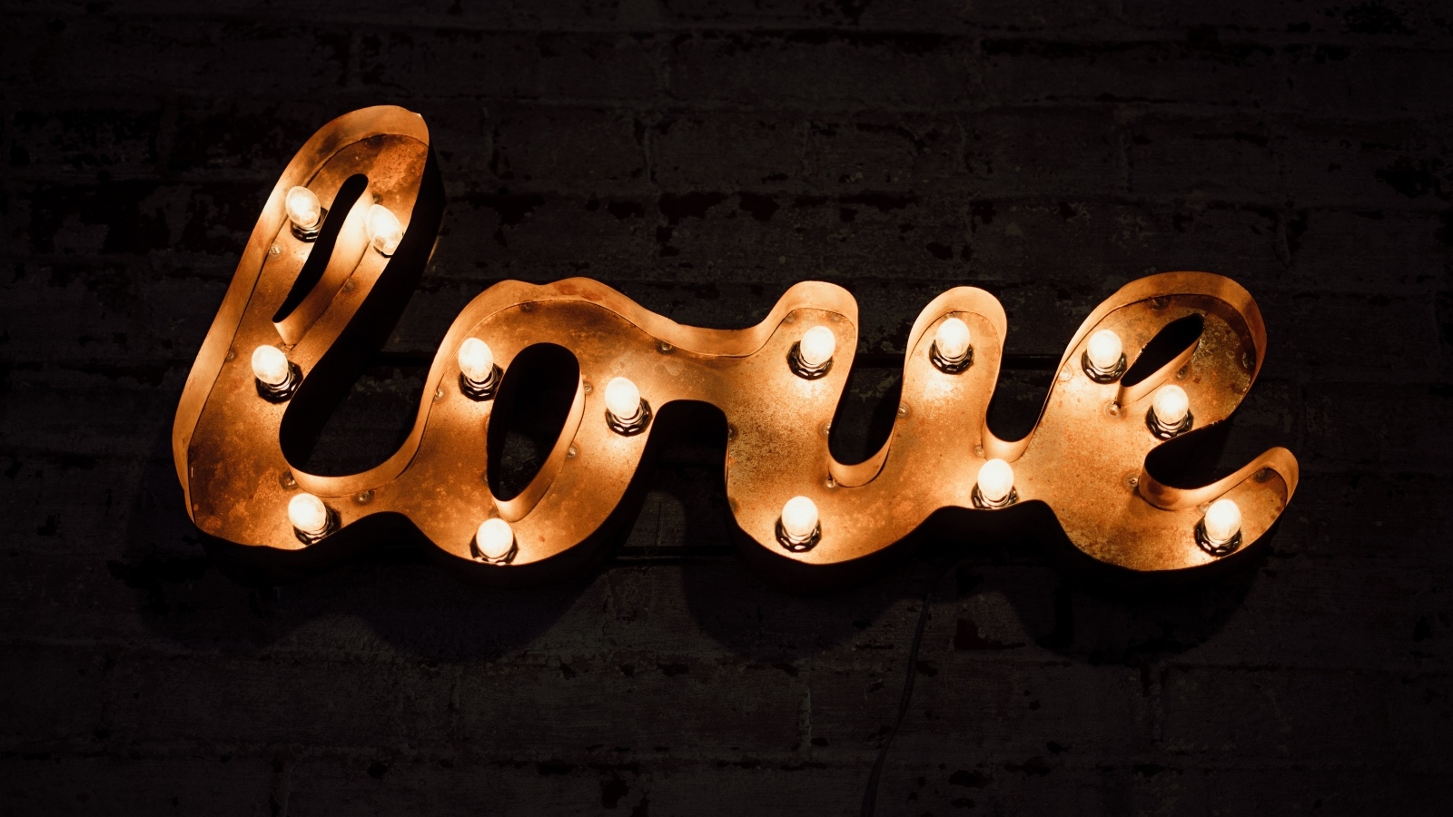 Светящаяся надпись любовь на черной стене