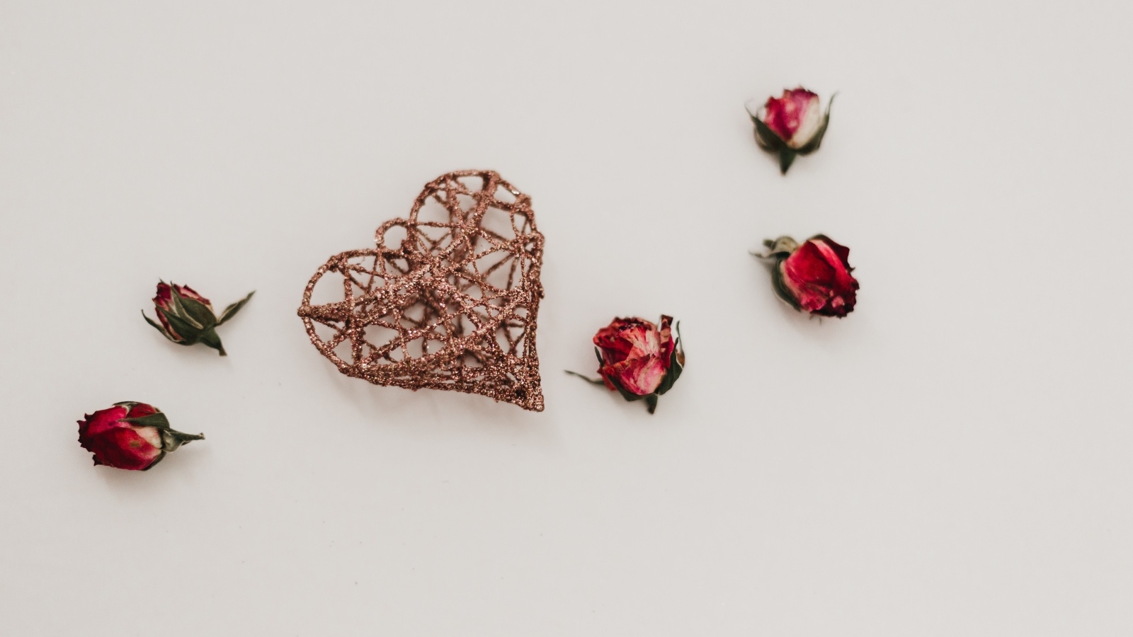 Плетеное сердце с сухими розами на сером фоне