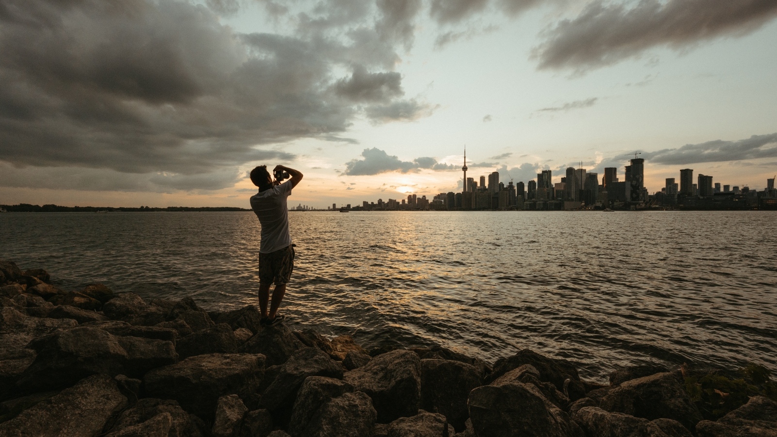 Мужчина делает фото города у моря