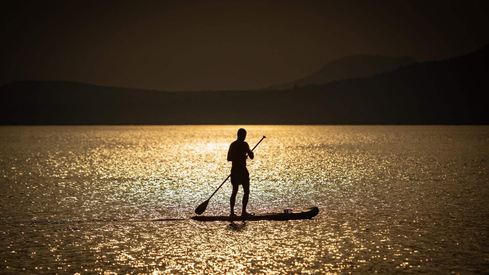 Мужчина серфингист в море на закате
