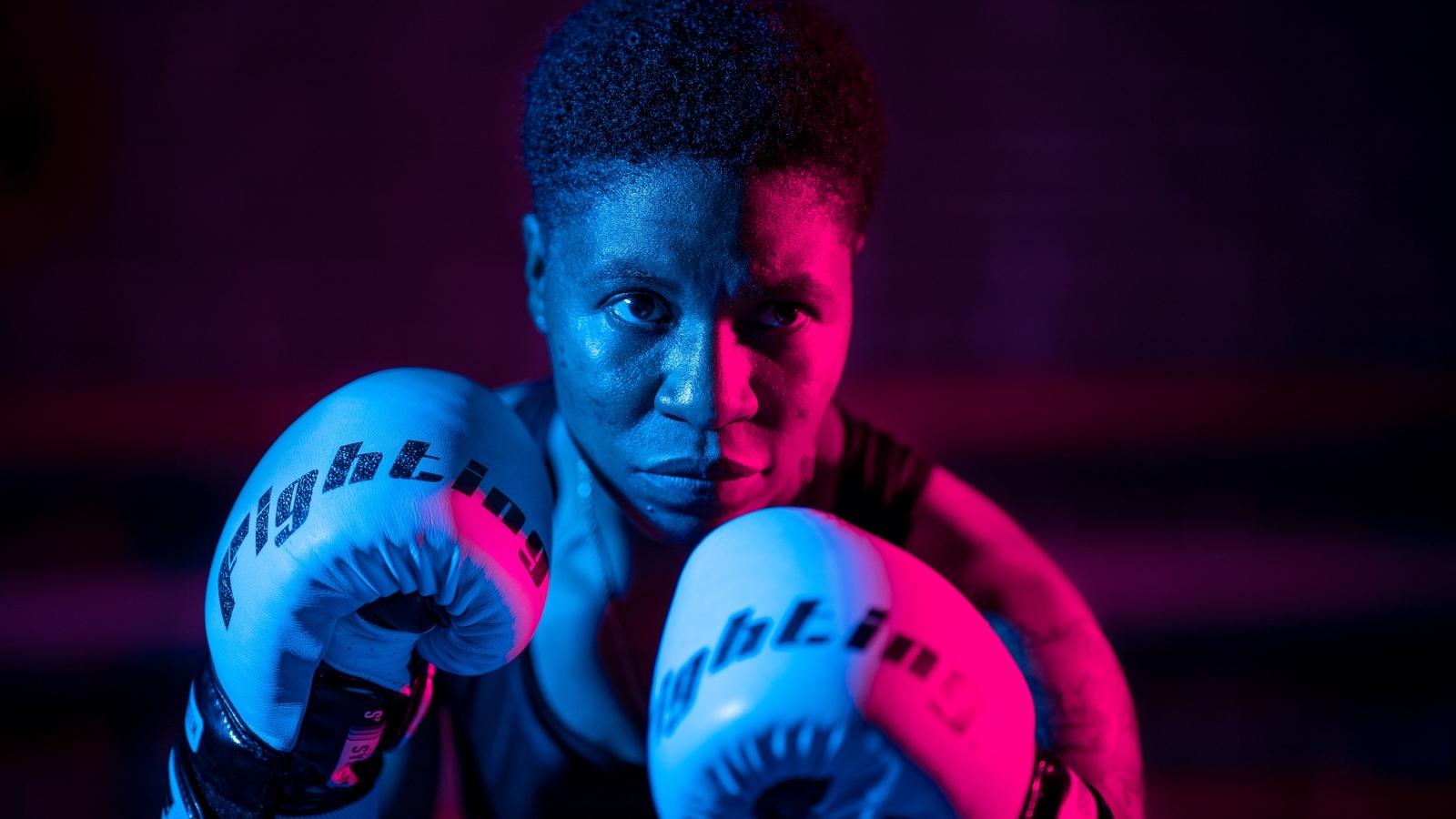 Мужчина в боксерских перчатках на черном фоне