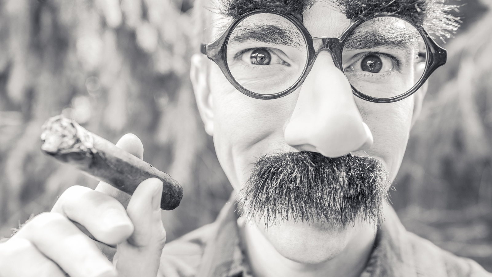 Мужчина в очках с сигарой в руке