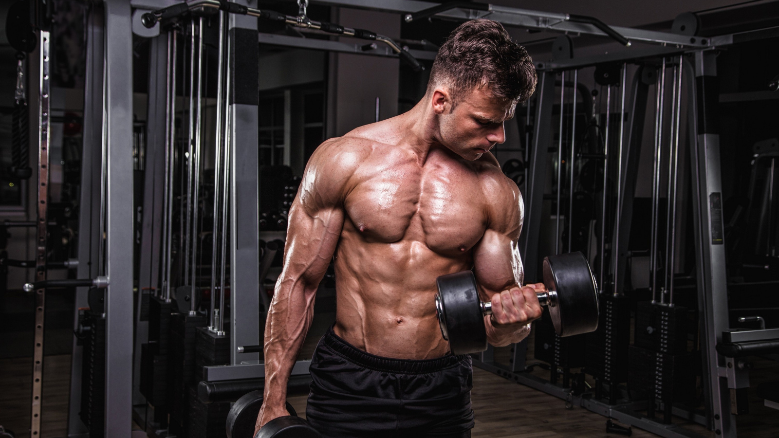 Сильный мужчина качает мускулы 