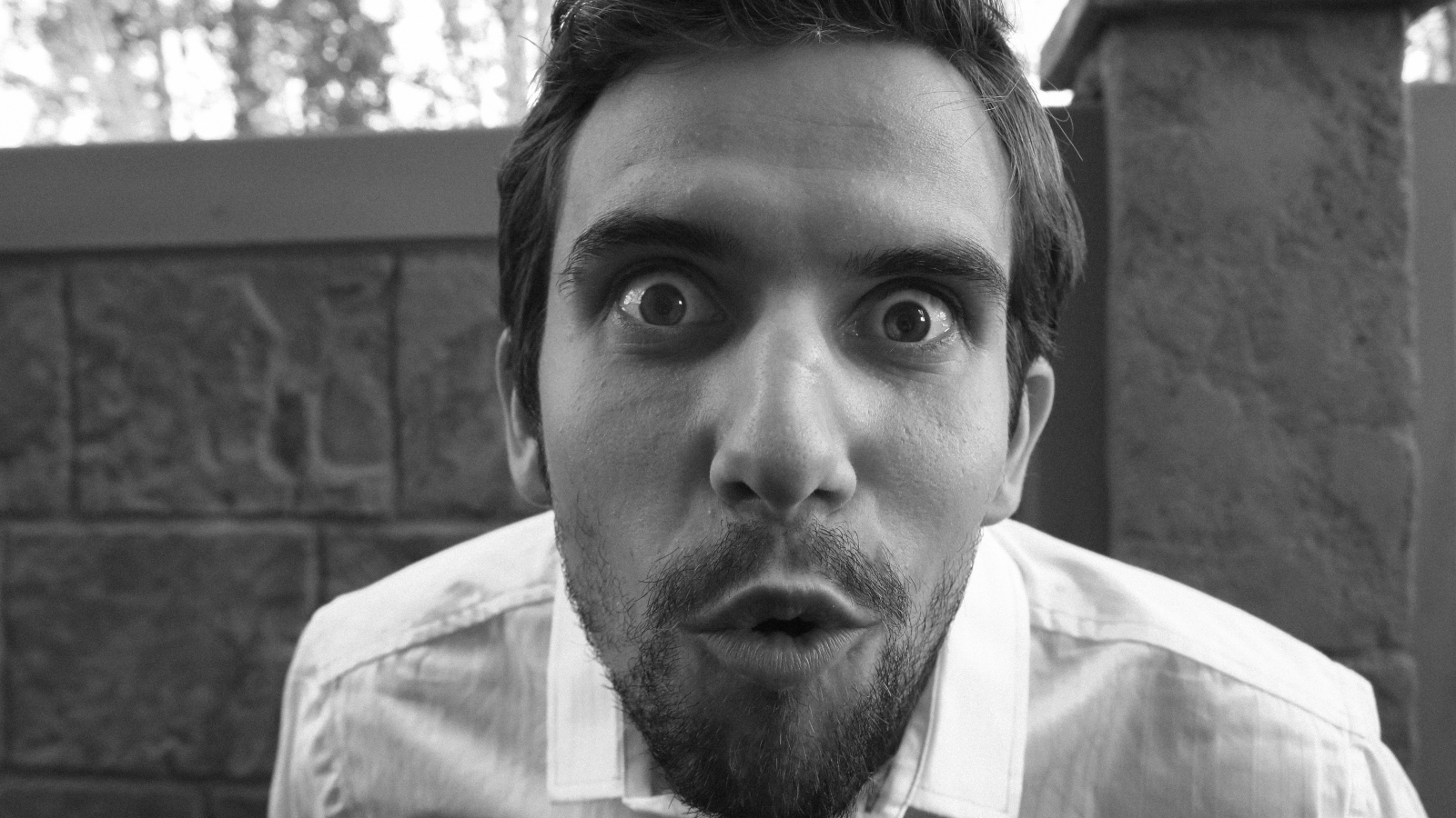 Удивленный взгляд мужчины в белой рубашке