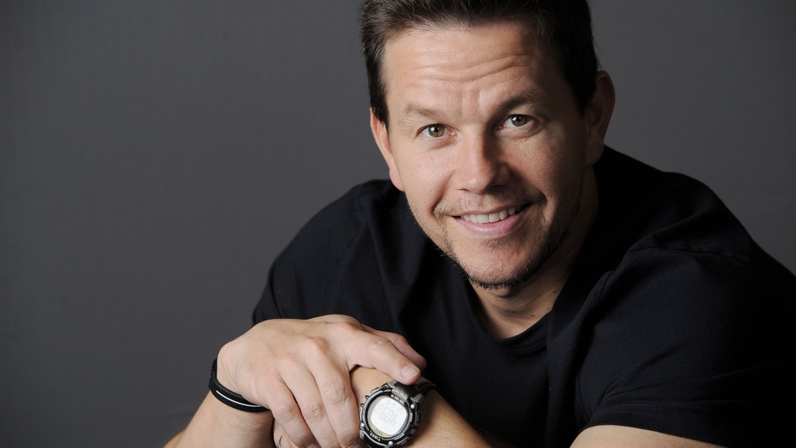 Улыбающийся Марк Уолберг с часами на руке