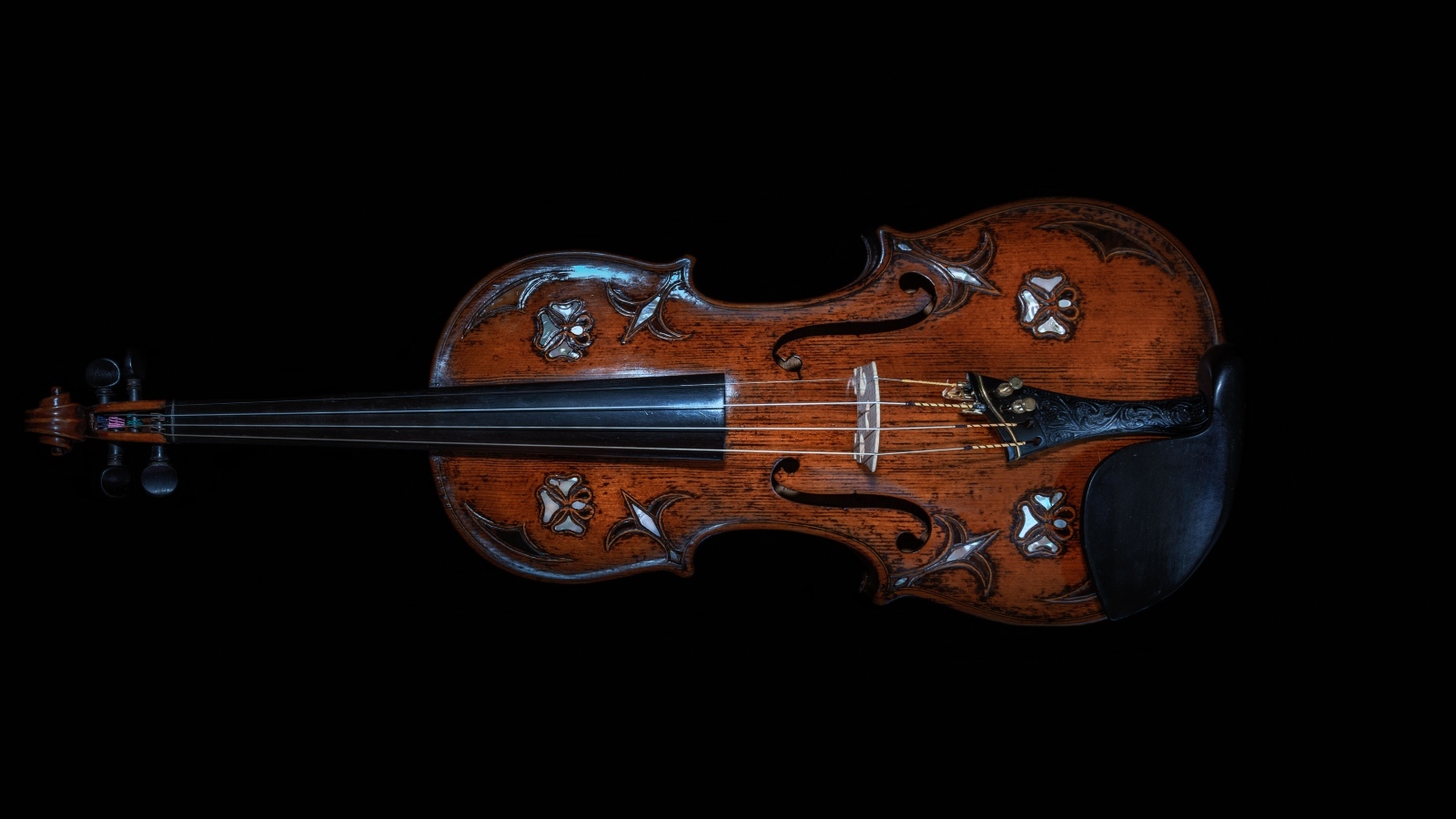 Большая деревянная скрипка на черном фоне