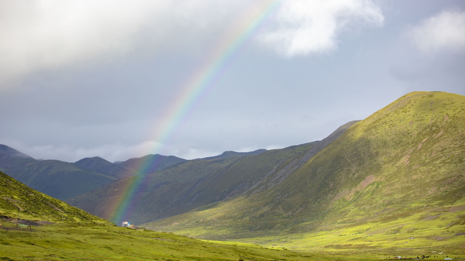 Радуга над покрытыми зеленью холмами