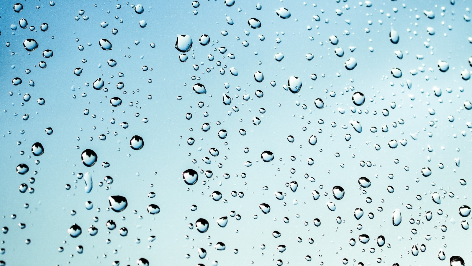 Капли дождя на голубом стекле