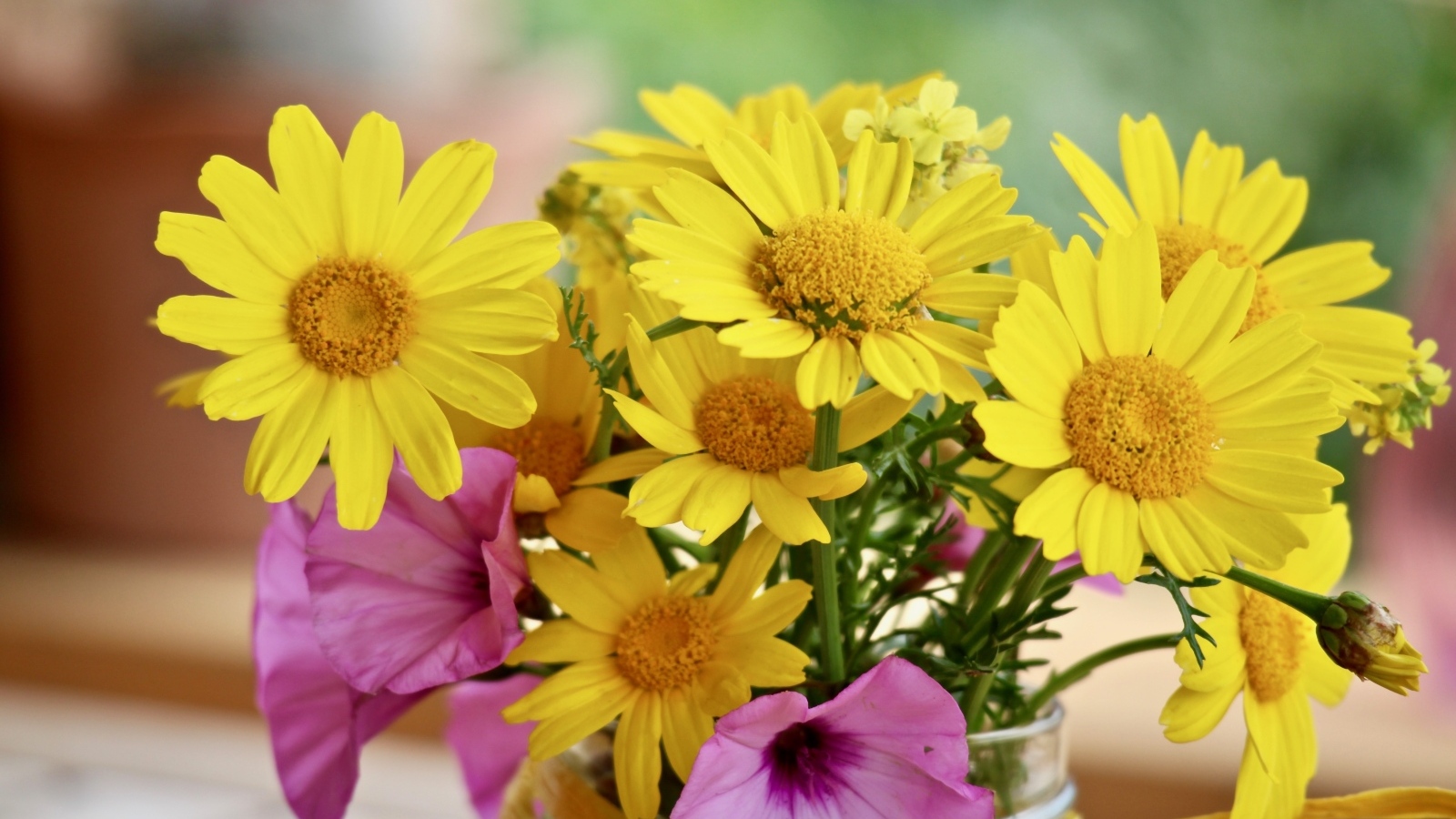 Букет желтых и розовых цветов в вазе на столе