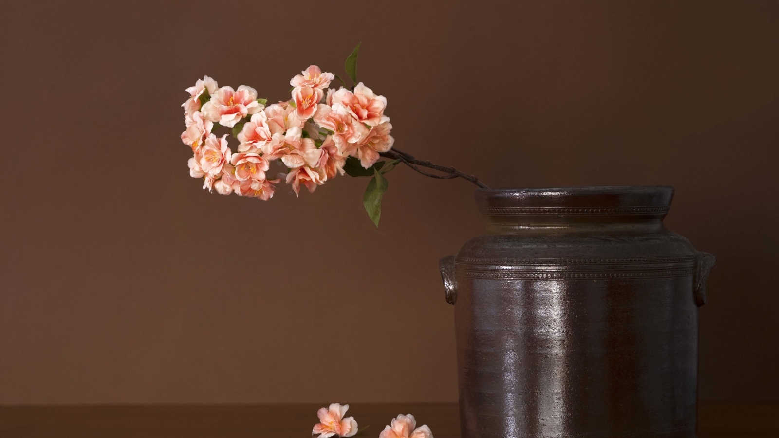 Ветка с розовыми цветами в вазе на столе