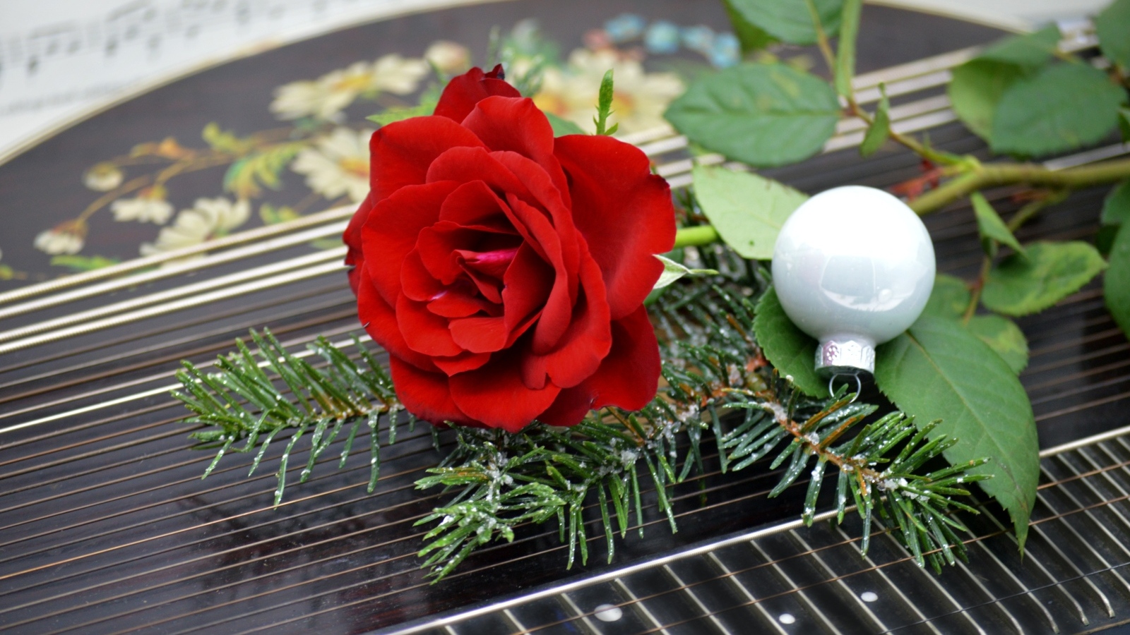 Красная роза с шариком и еловой веткой