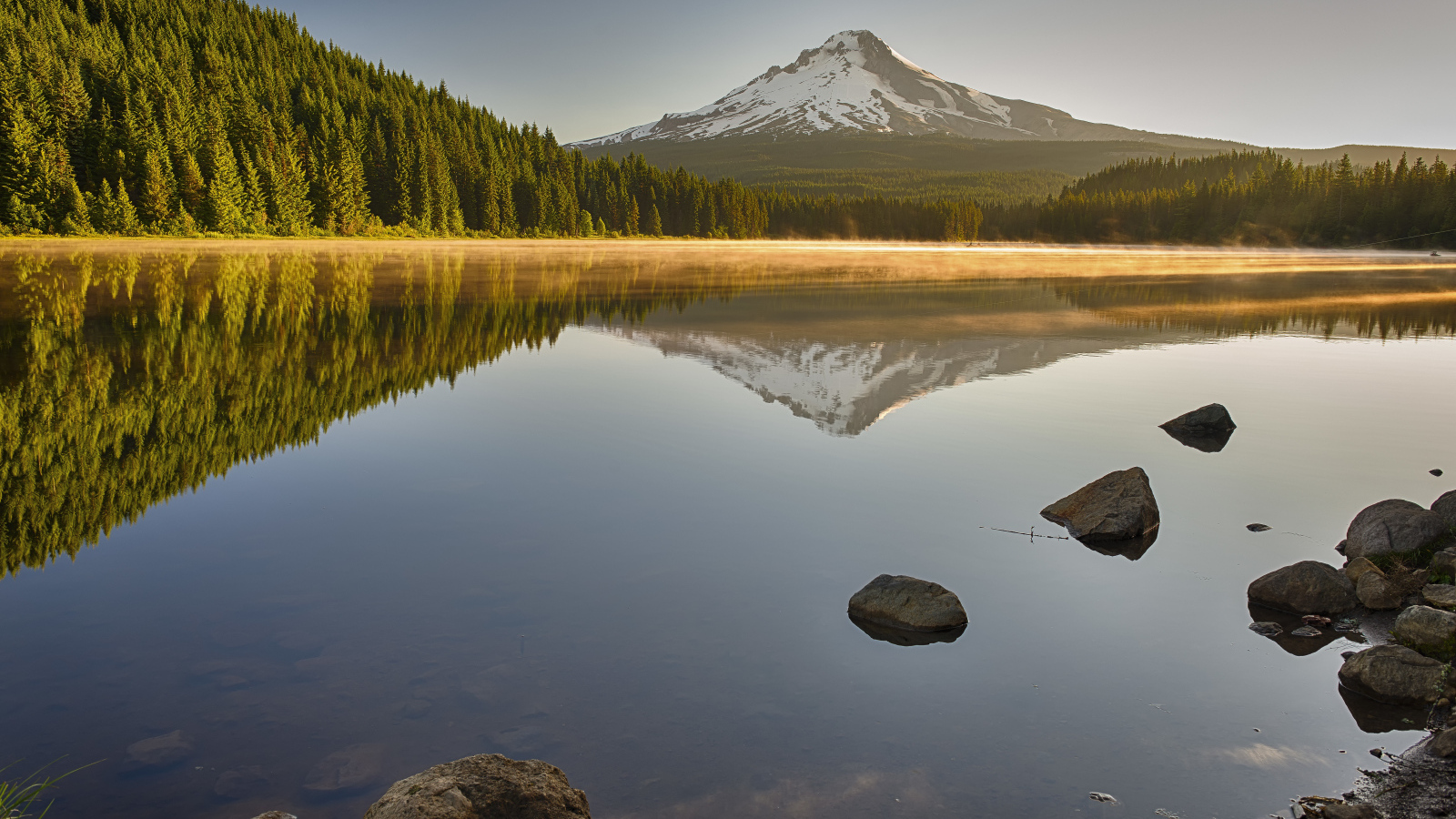 Красивый вид на озеро, лес и заснеженную гору