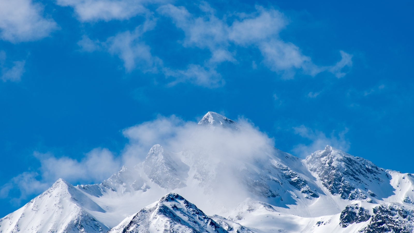 Голубое небо над покрытыми снегом горами