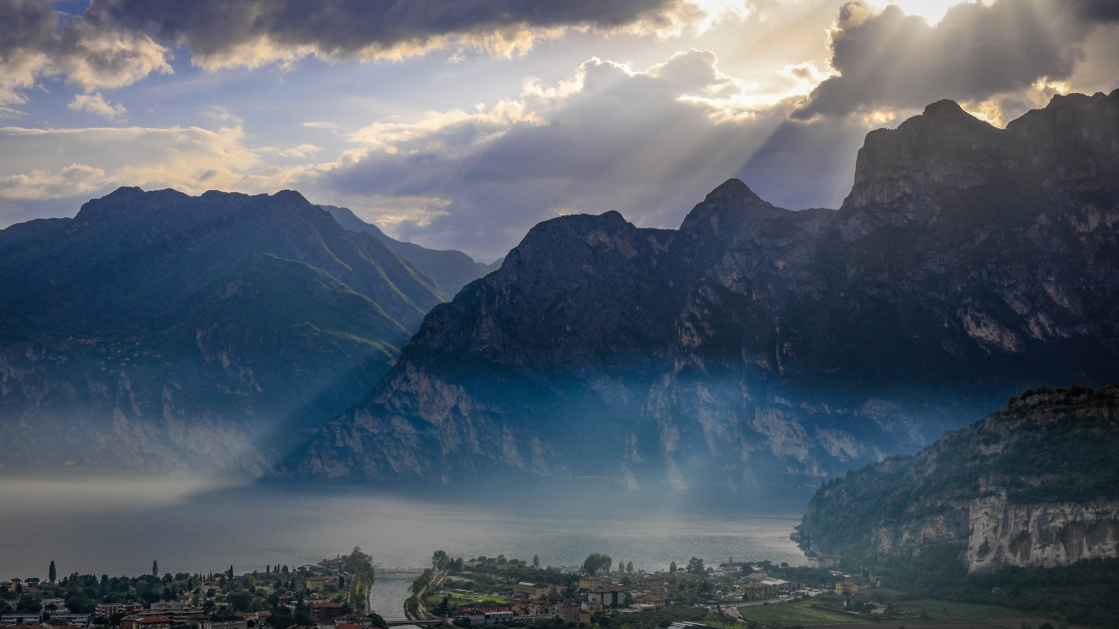 Лучи солнца покрывают горы и город 