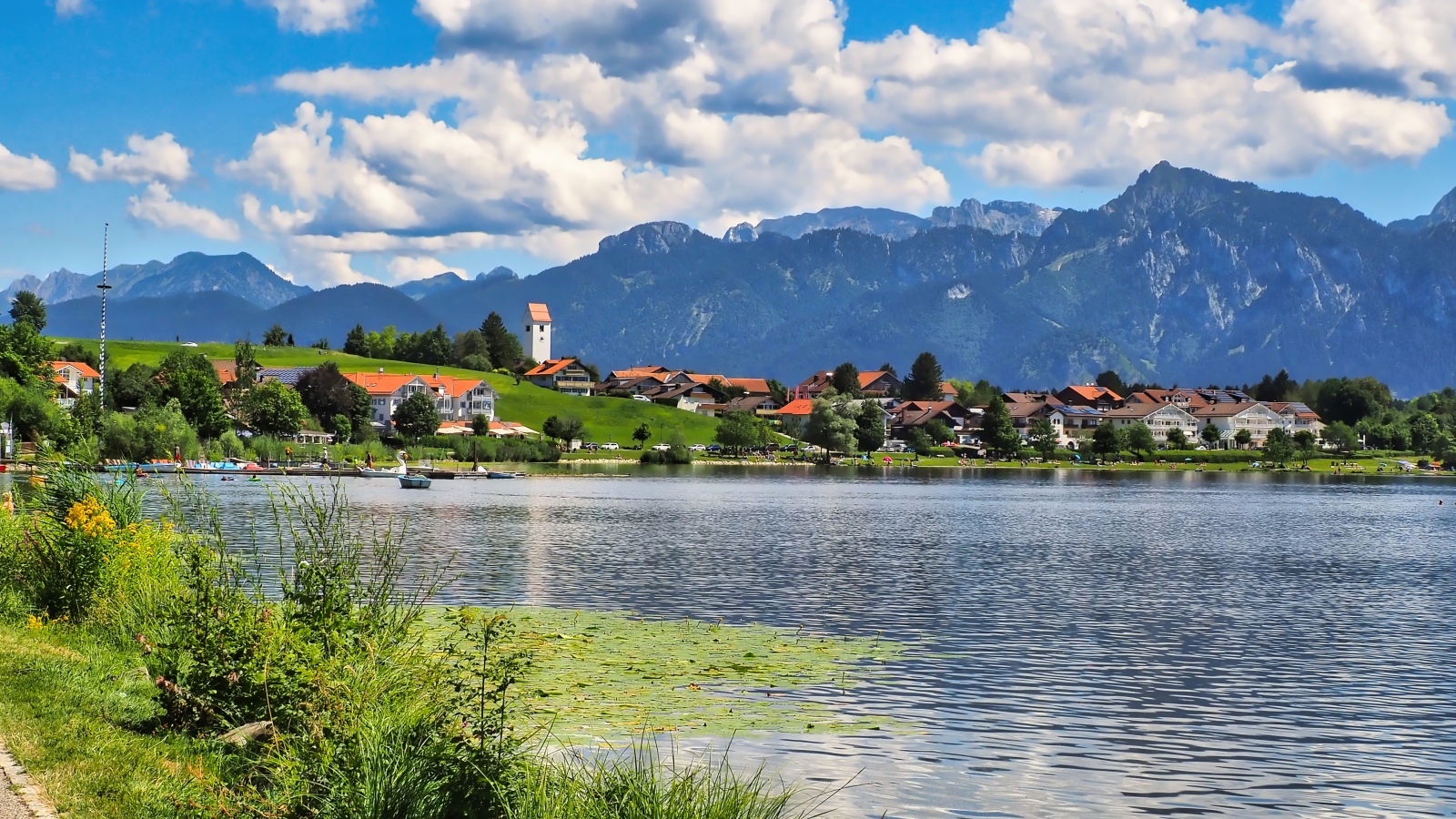 Красивый вид на озеро и горы под голубым небом с белыми облаками