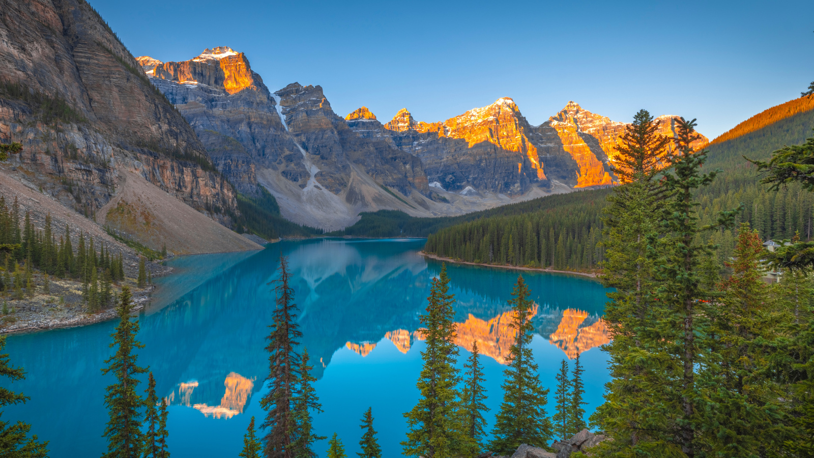 Солнце над вершинами гор у голубого озера