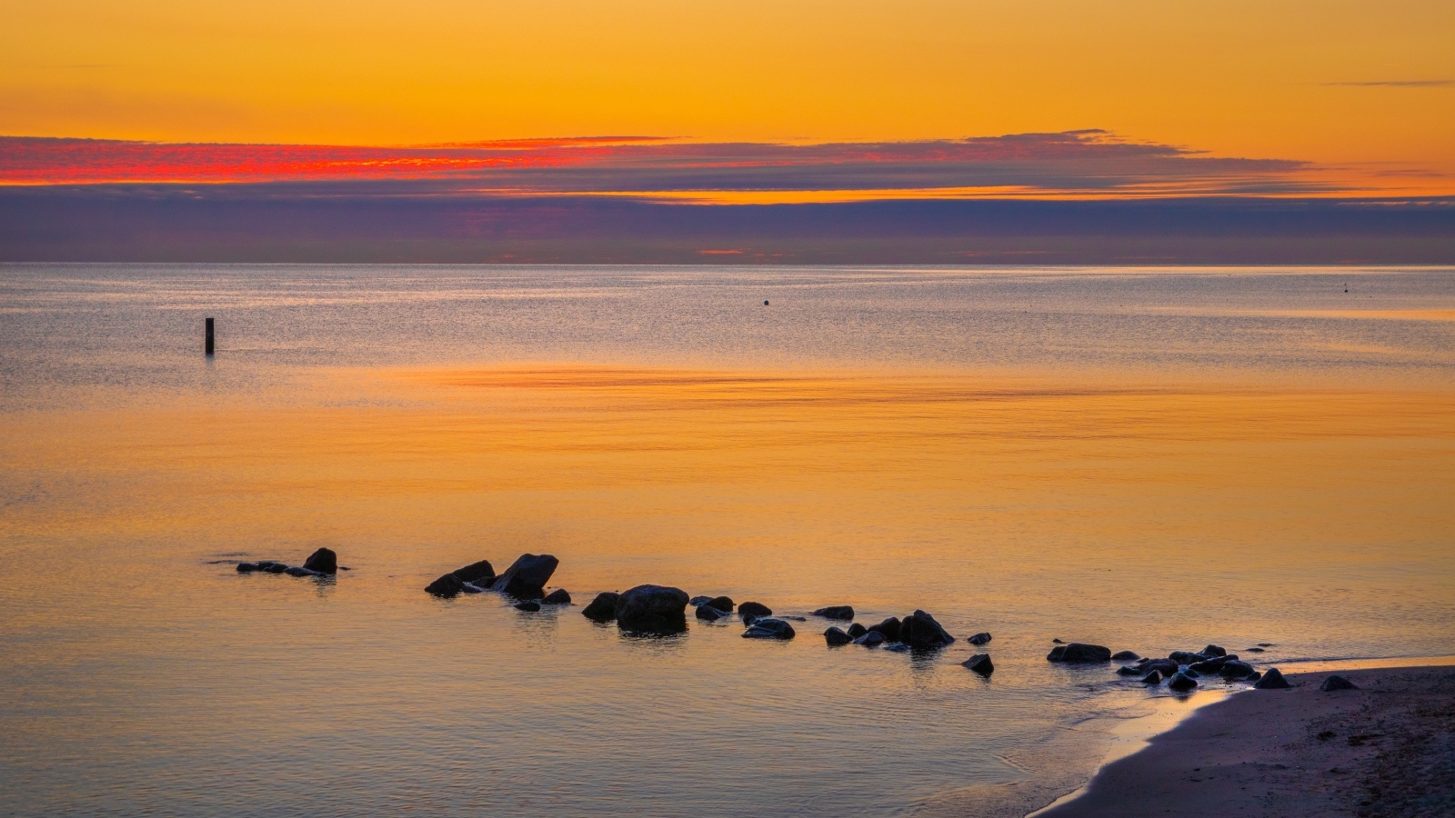 Спокойное теплое море на закате в сумерках