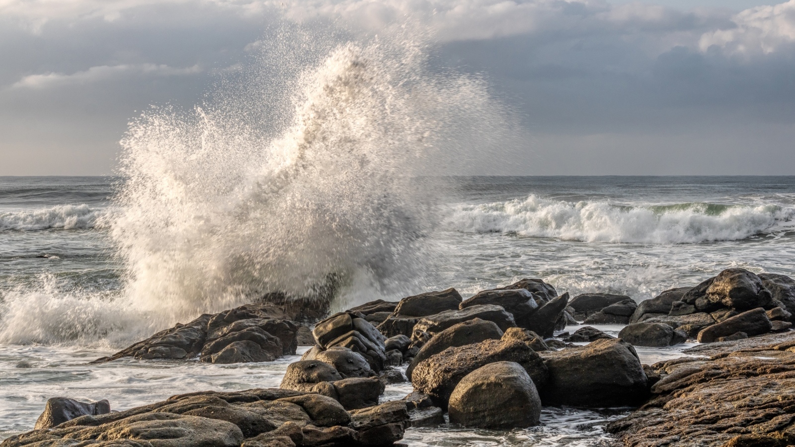Морские волны бьются о камни на берегу