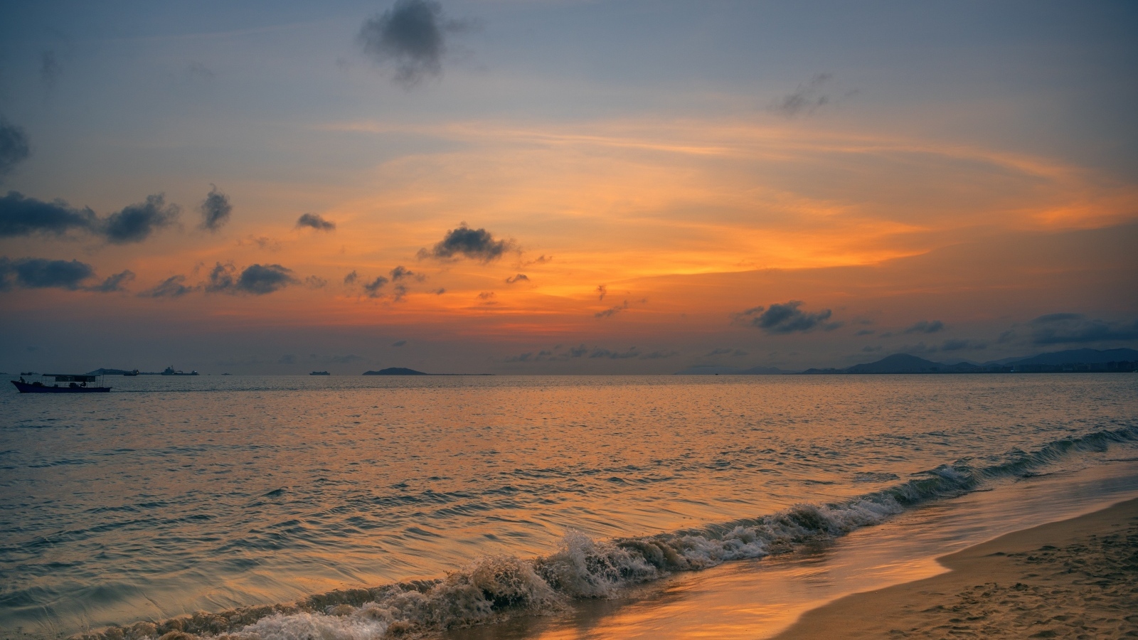 Морские волны омывают берег на закате