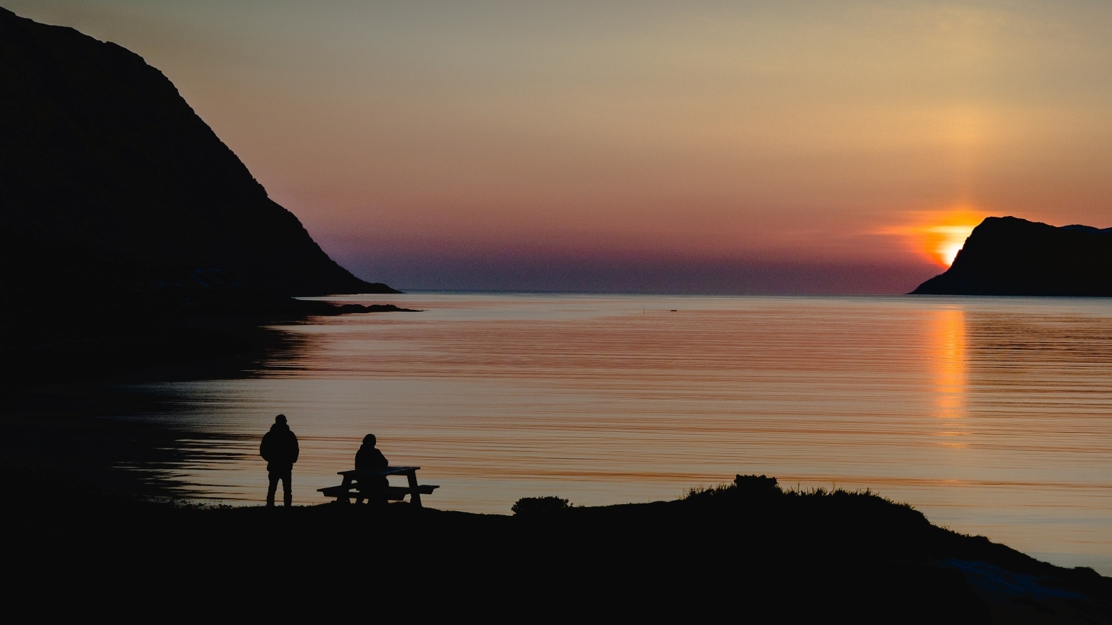 Солнце скрывается за горой в заливе
