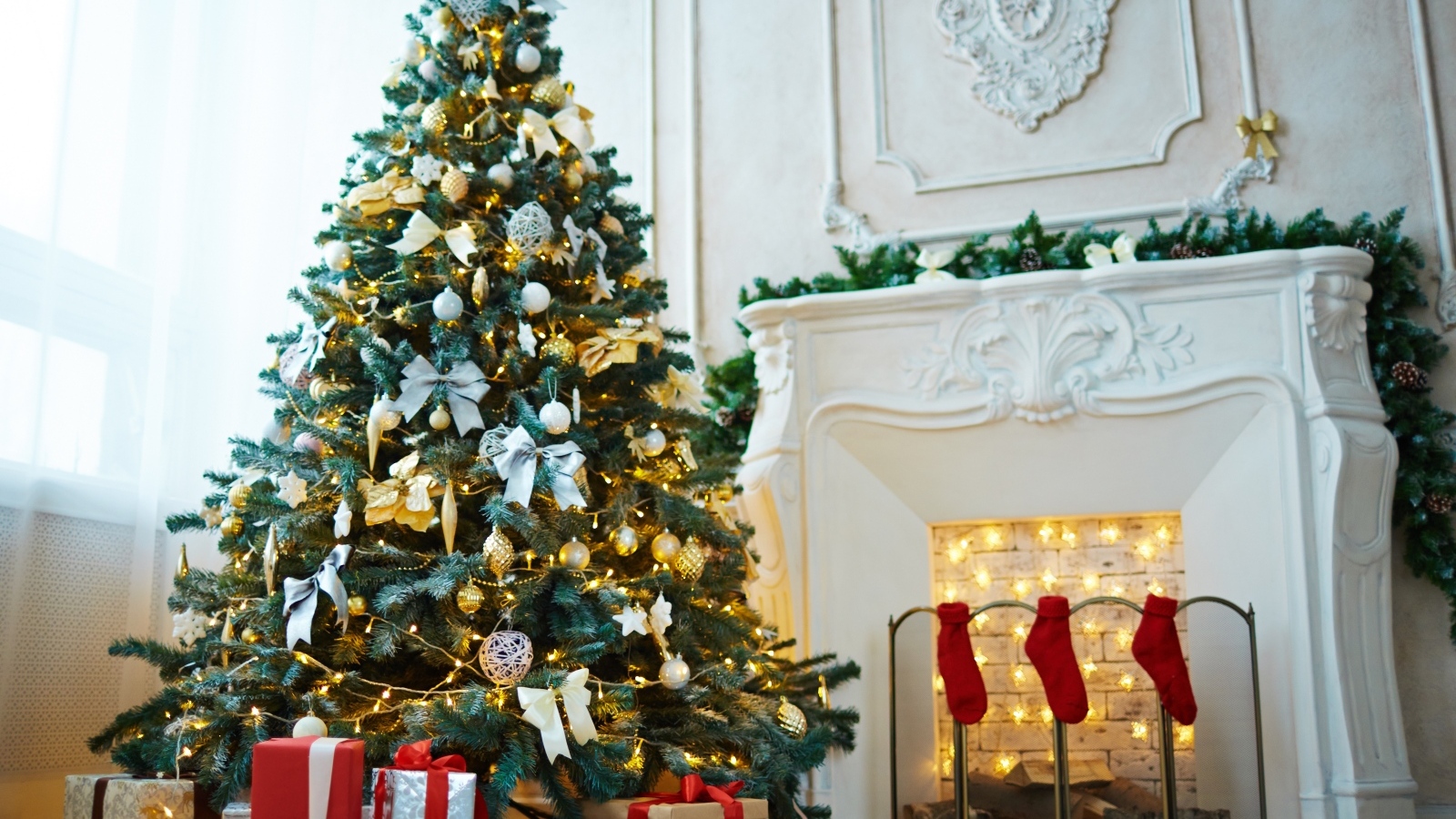 Красивая наряженная ель в комнате с камином