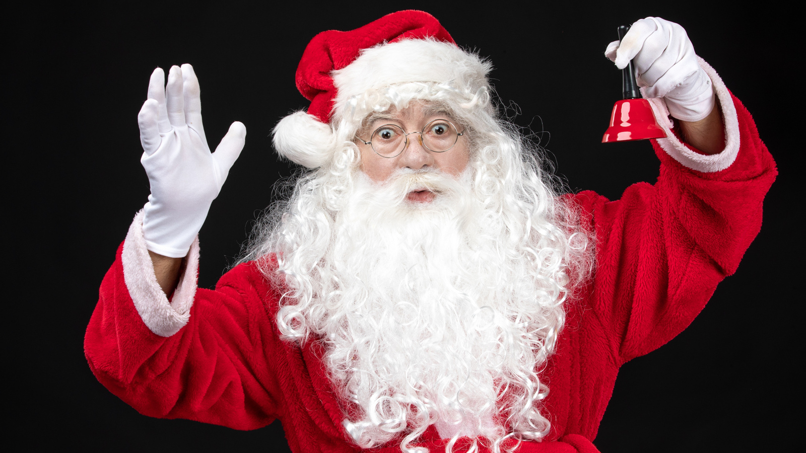 Удивленный Санта Клаус с колокольчиком в руках