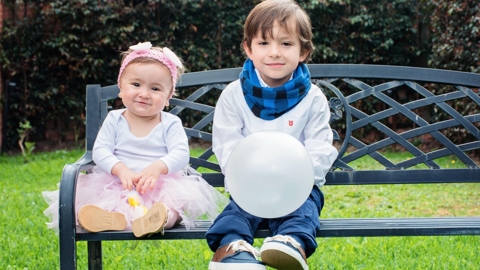 Мальчик и девочка сидят на лавке в парке