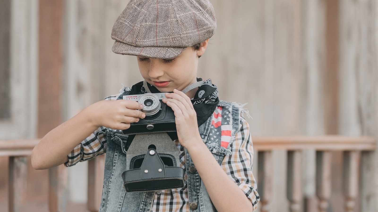 Мальчик в кепке с фотоаппаратом в руках