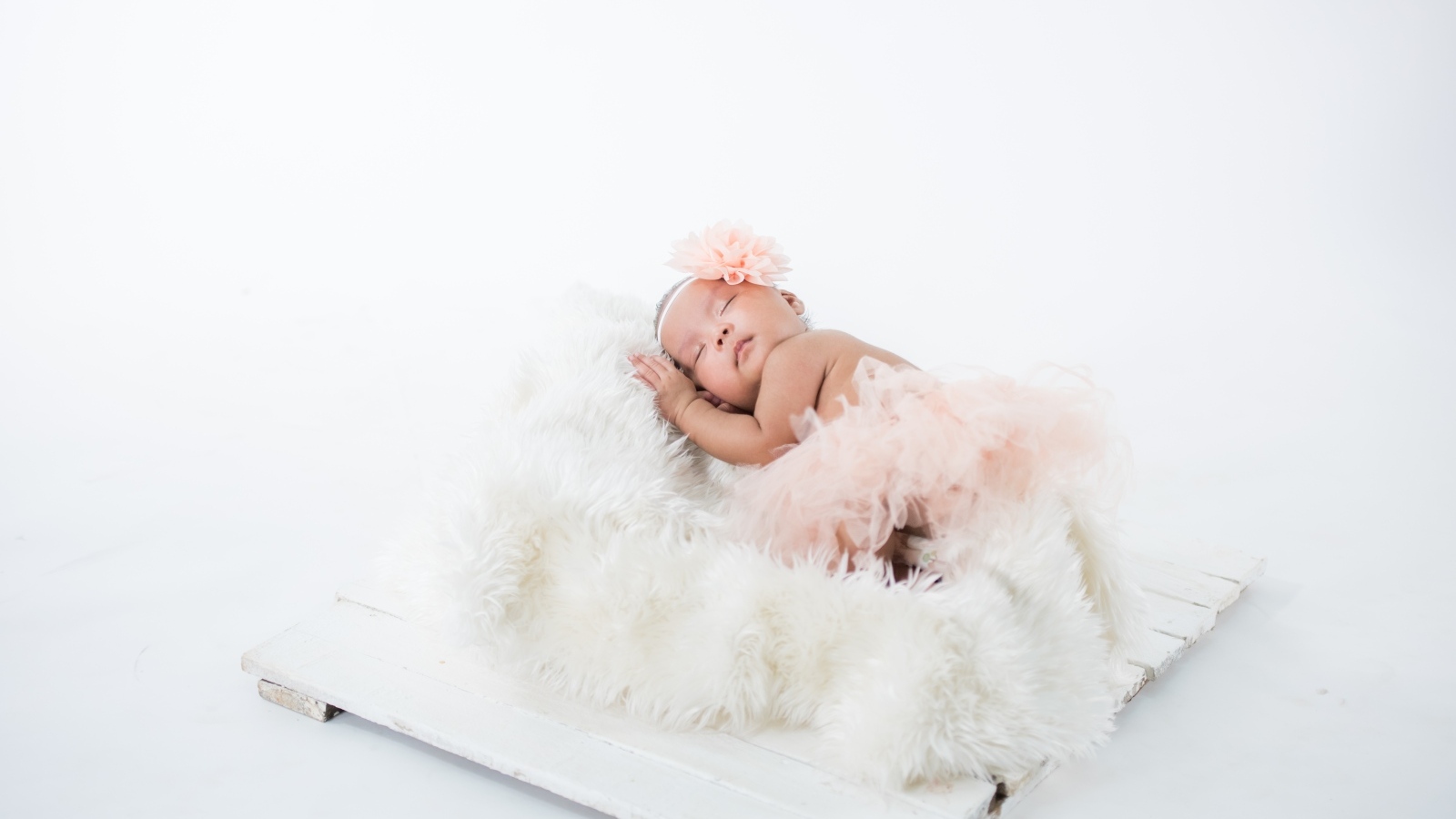 Милая спящая девочка в розовой юбке 