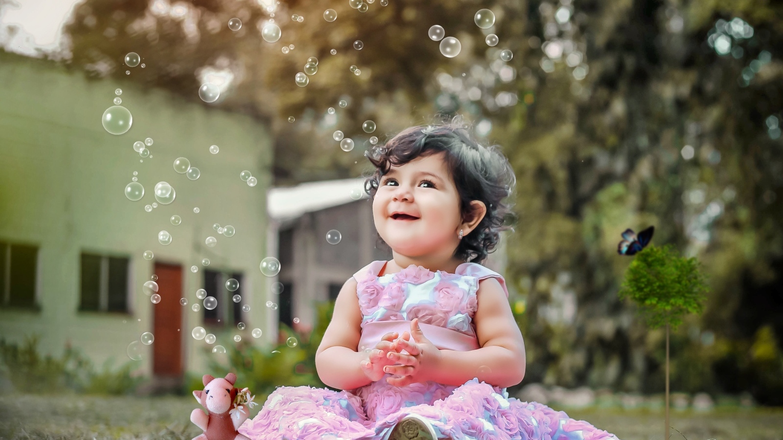 Маленькая девочка радуется мыльным пузырям