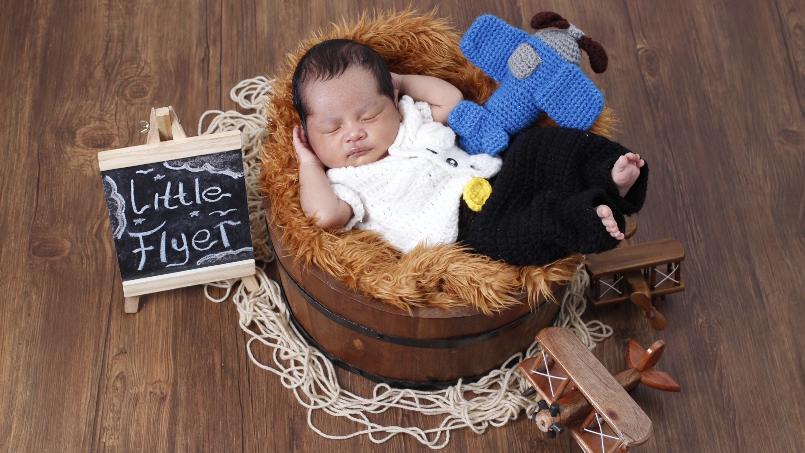 Маленький новорожденный малыш спит в бочке 