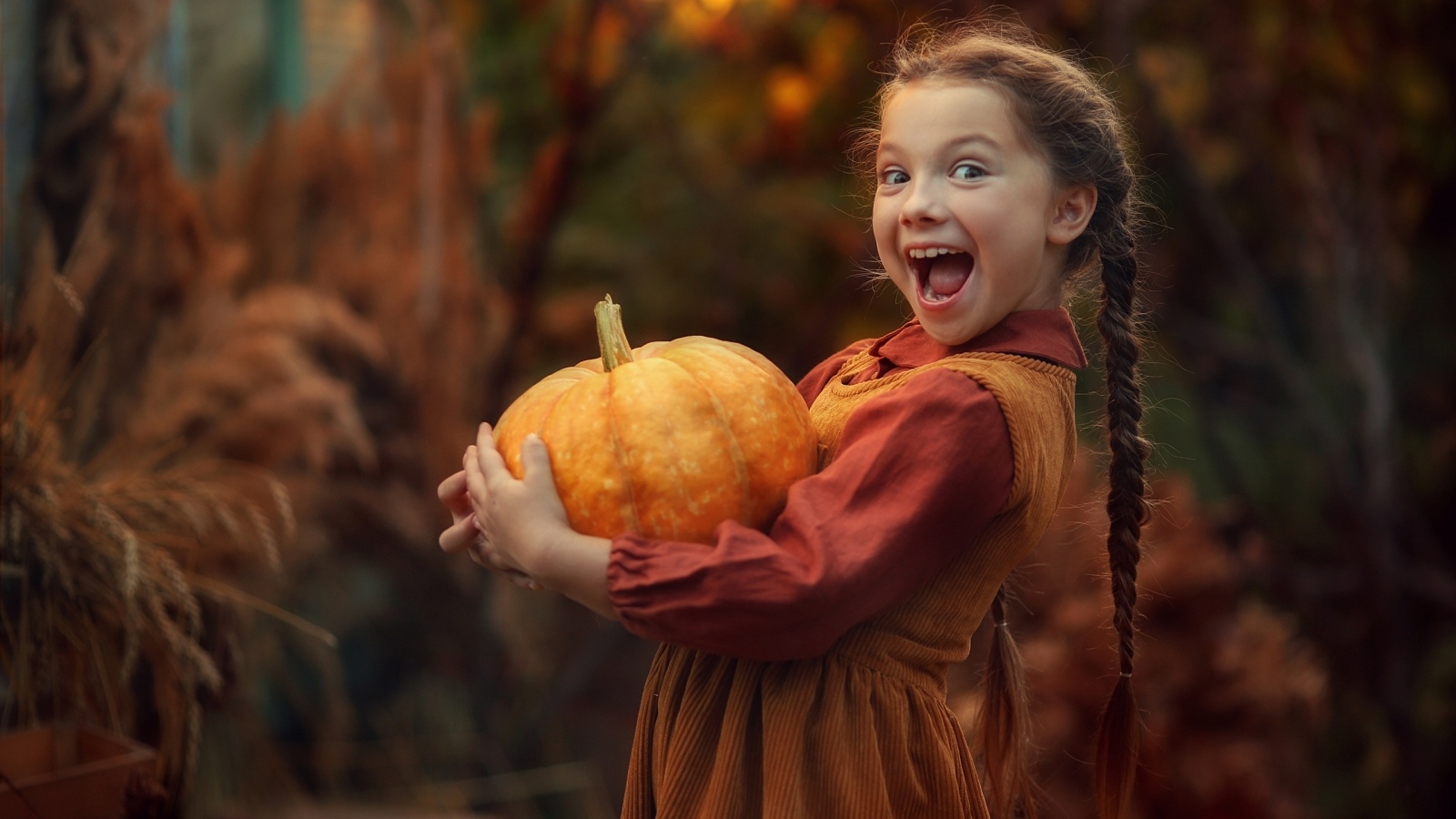 Маленькая рыжеволосая девочка с тыквой