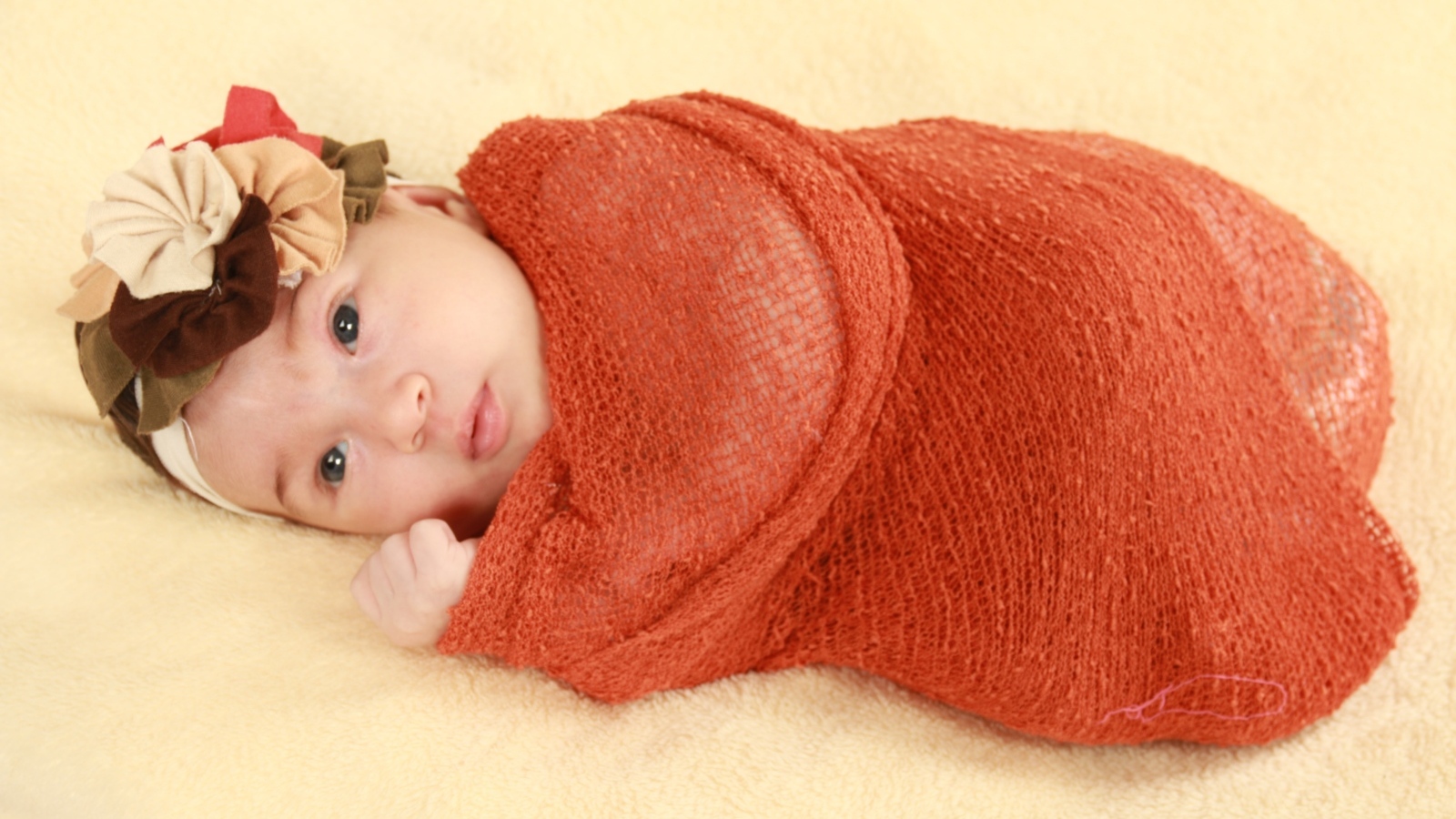 Новорожденная девочка в красном покрывале