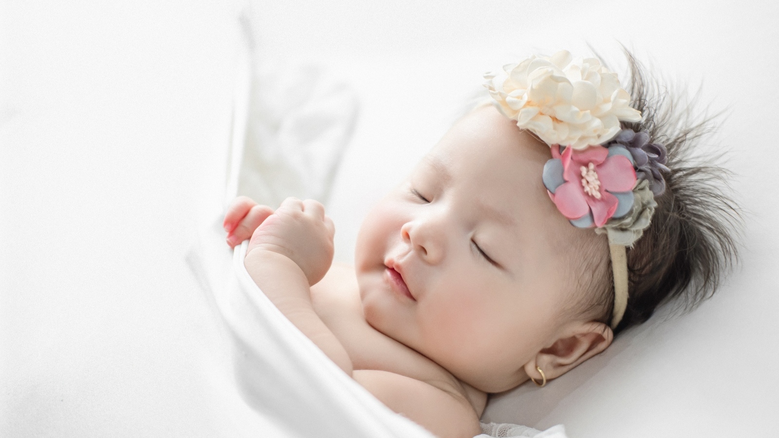 Новорожденная девочка с повязкой на голове