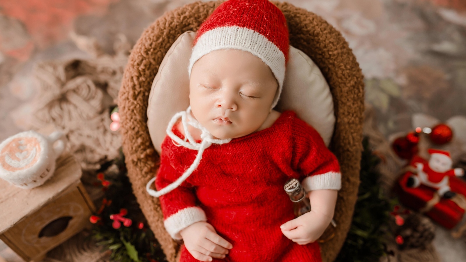 Новорожденный малыш в красном вязаном костюме