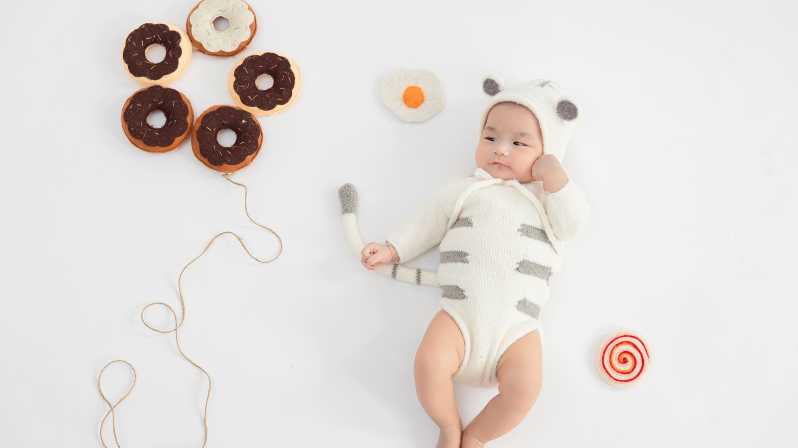 Новорожденный ребенок в костюме с пончиками
