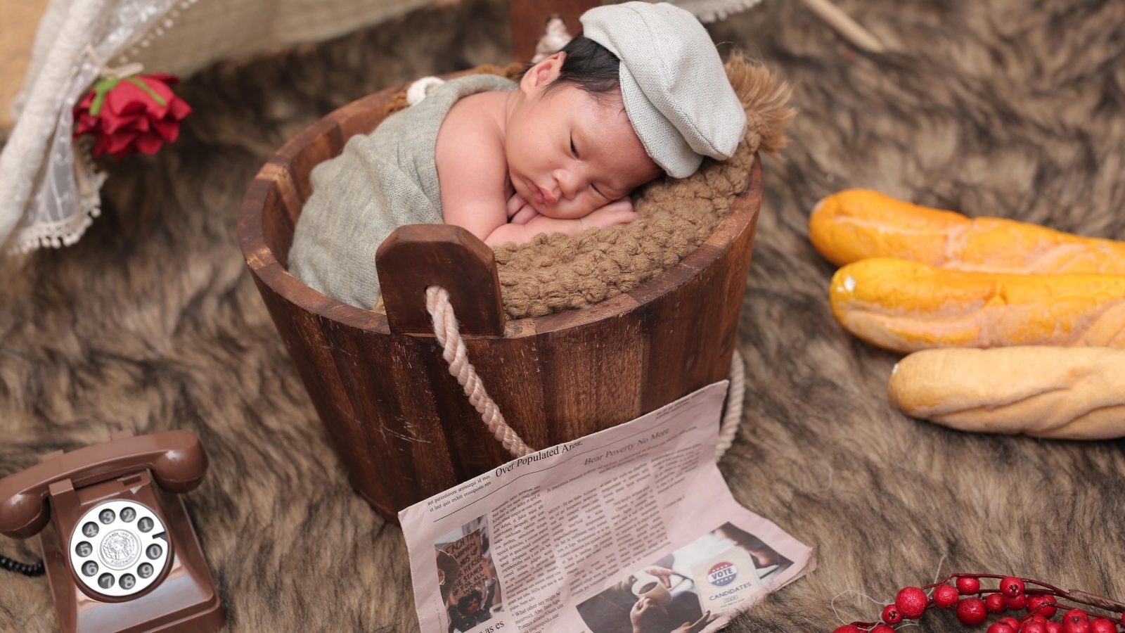 Новорожденный маленький мальчик в деревянном ведре на фотосессии 