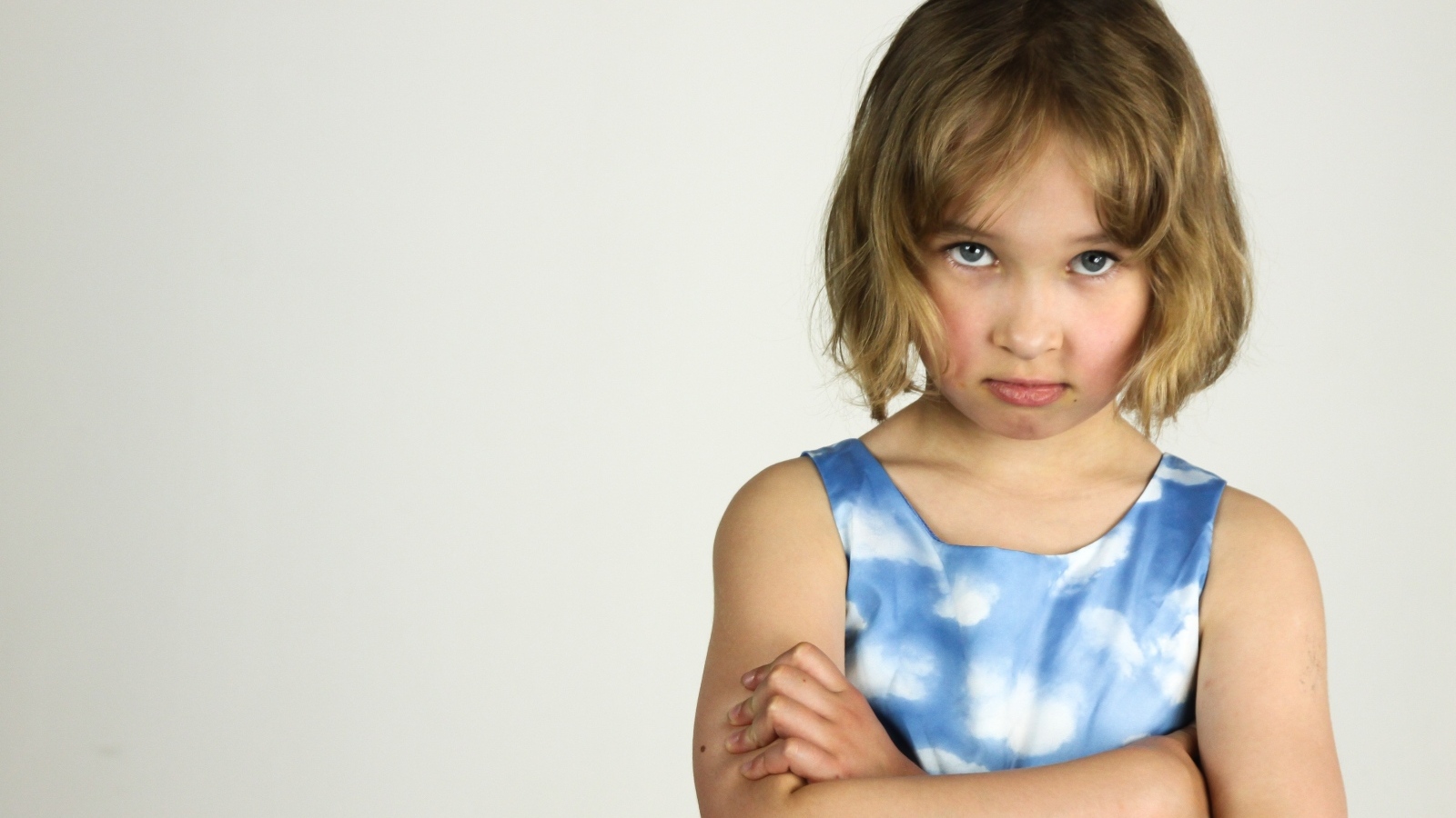 Серьезная девочка на сером фоне