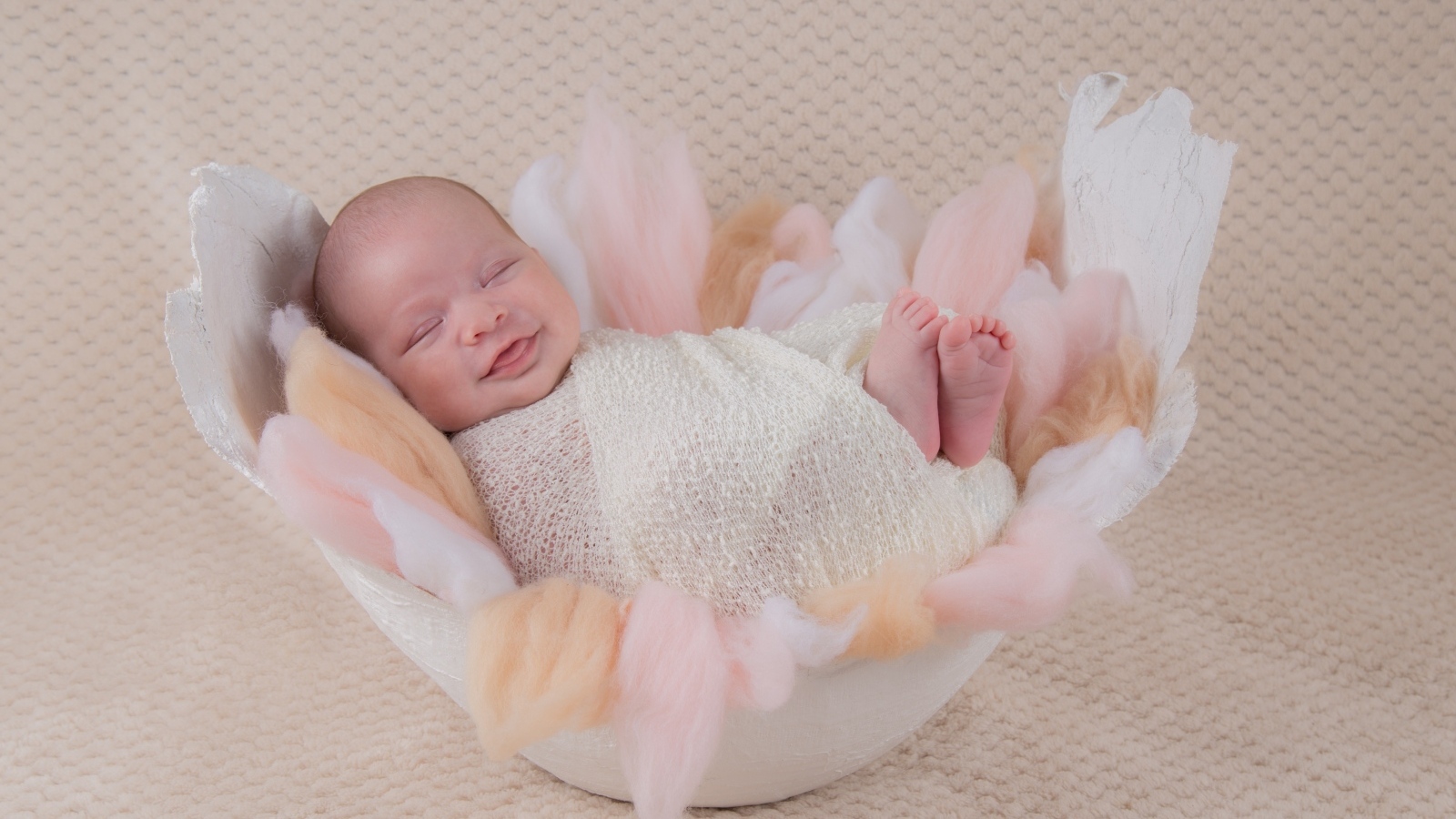 Улыбающийся спящий новорожденный малыш