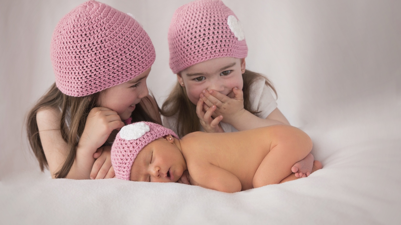 Три маленькие девочки в вязаных шапках