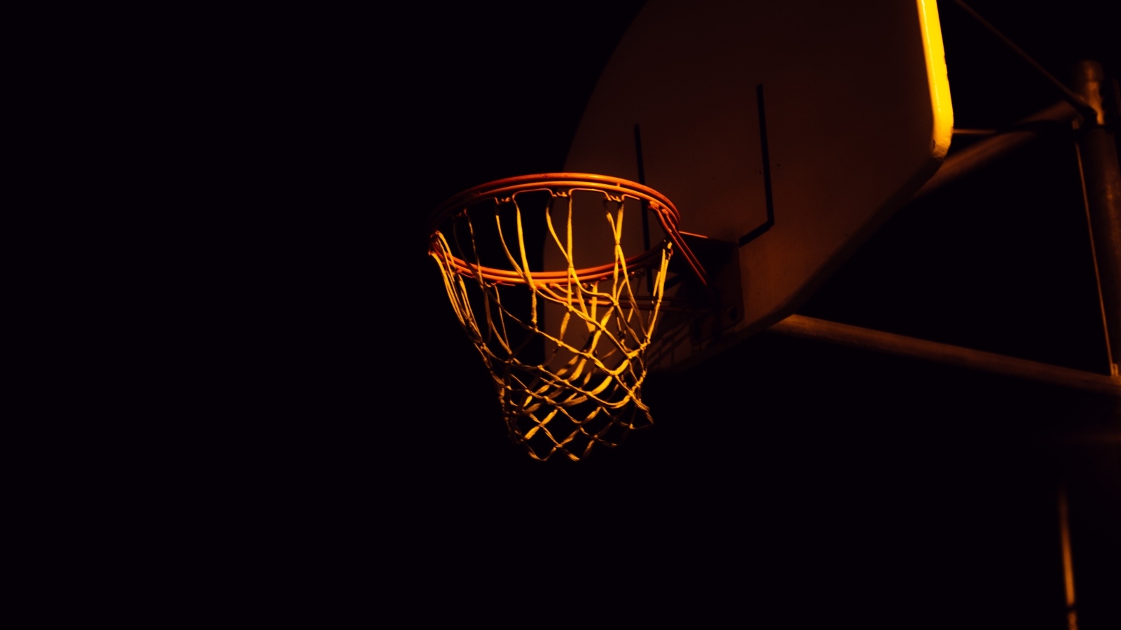 Баскетбольное кольцо в лучах света ночью