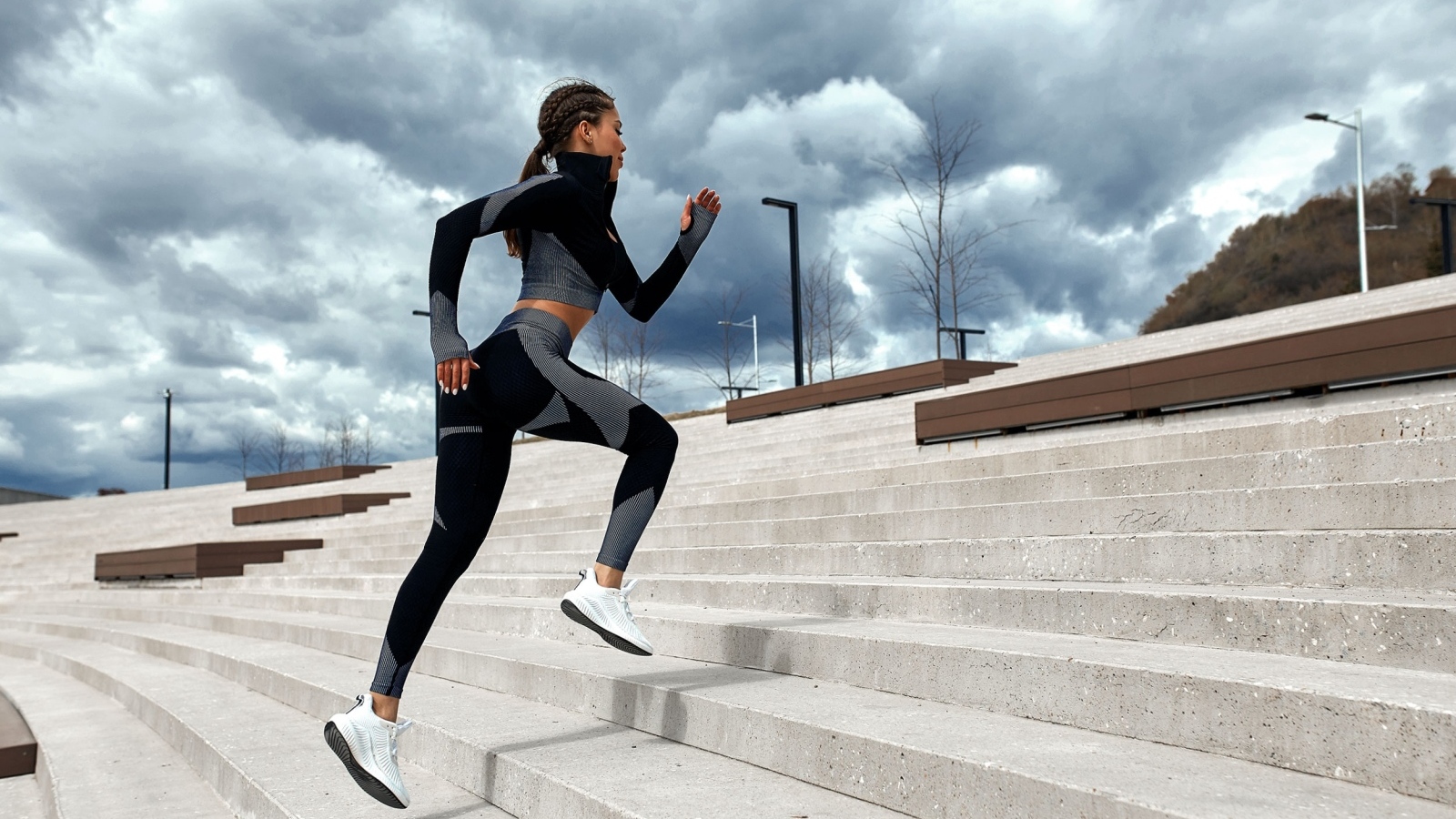 Девушка спортсменка бежит по лестнице