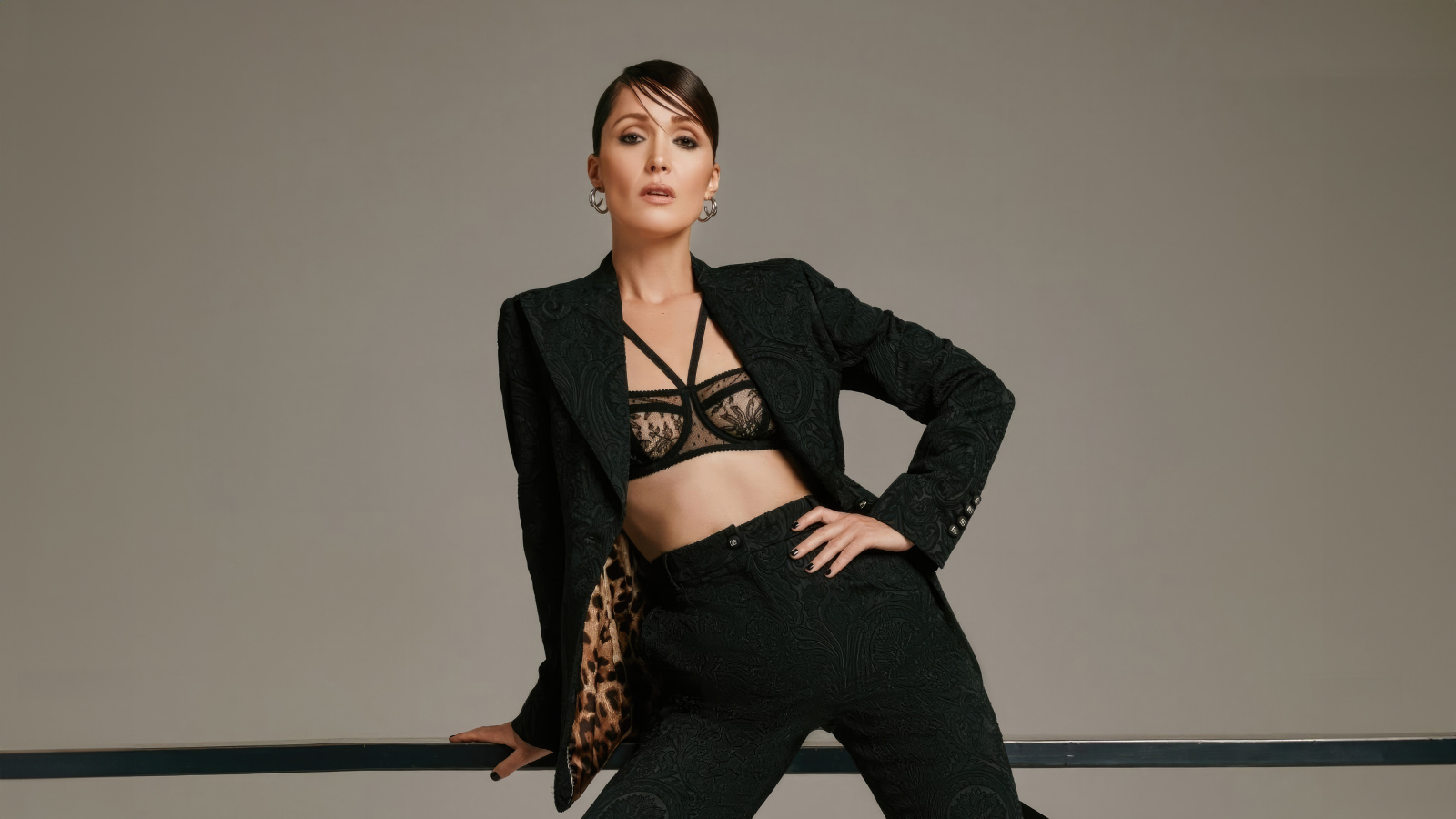 Эффектная актриса Роуз Бёрн в черном костюме на сером фоне