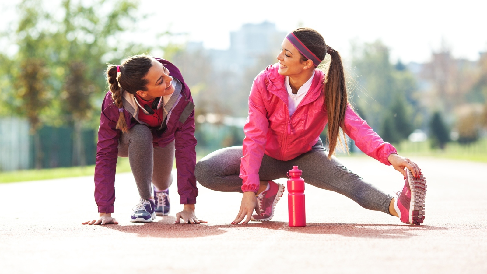 Две спортивные девушки делают растяжку 