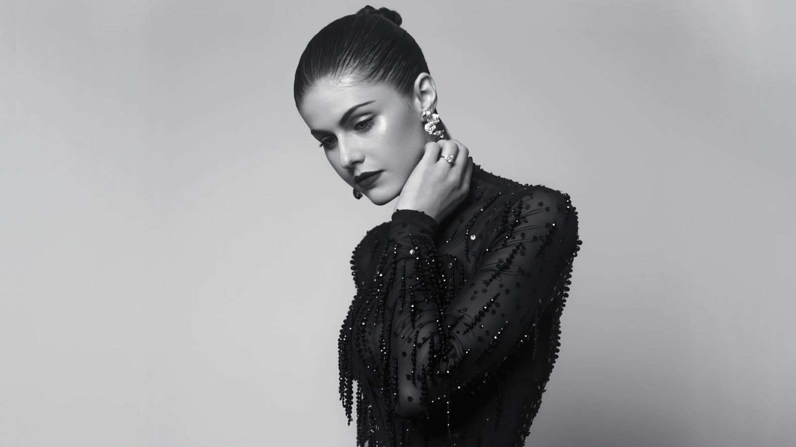 Молодая актриса Александра Даддарио в черном платье на сером фоне