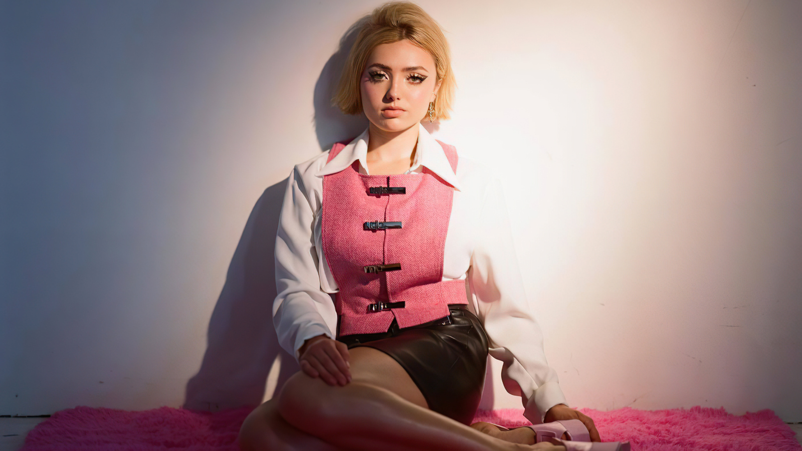 Молодая девушка Пейтон Рой Лист сидит у стены