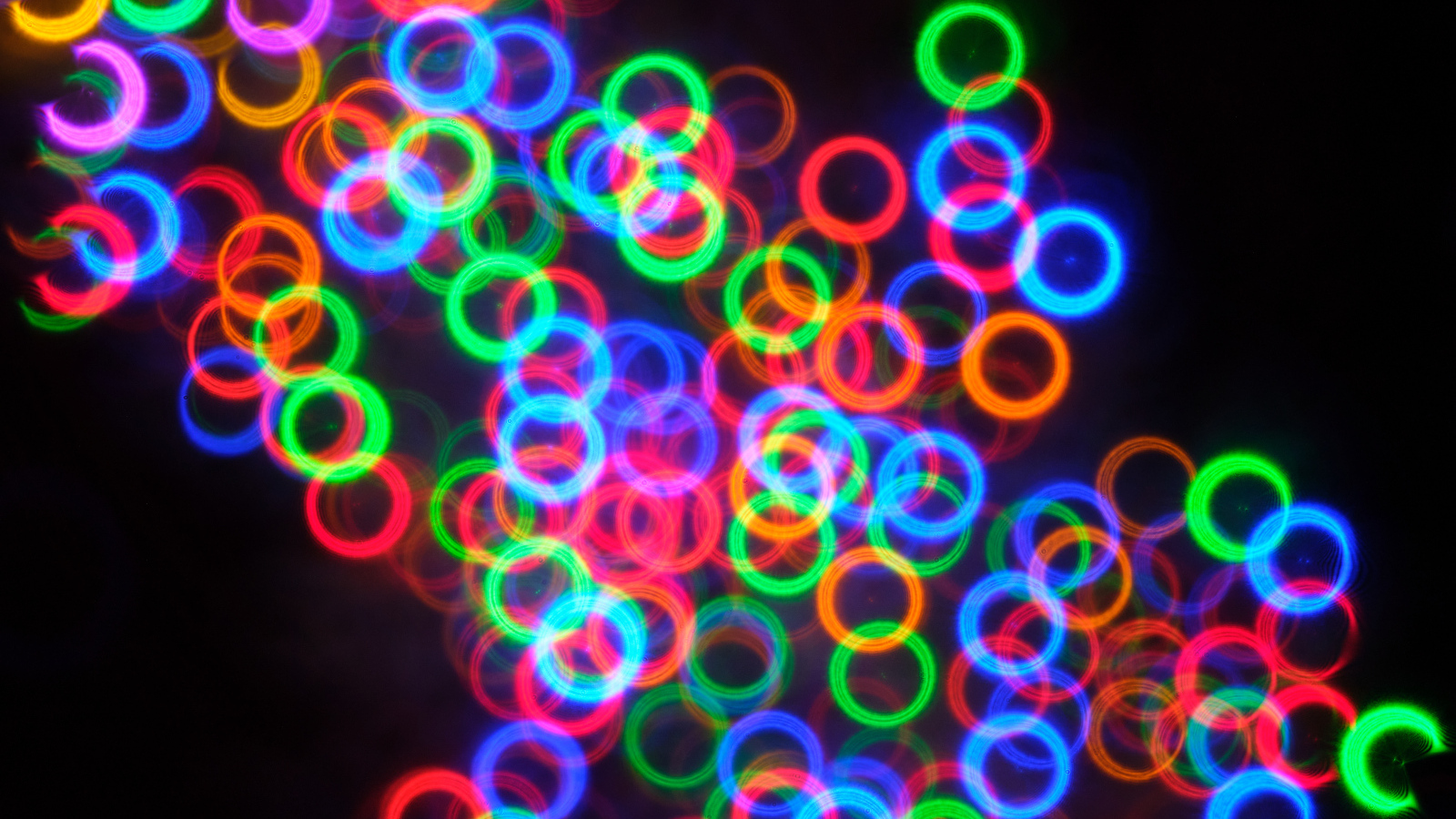 Разноцветные неоновые круги на черном фоне