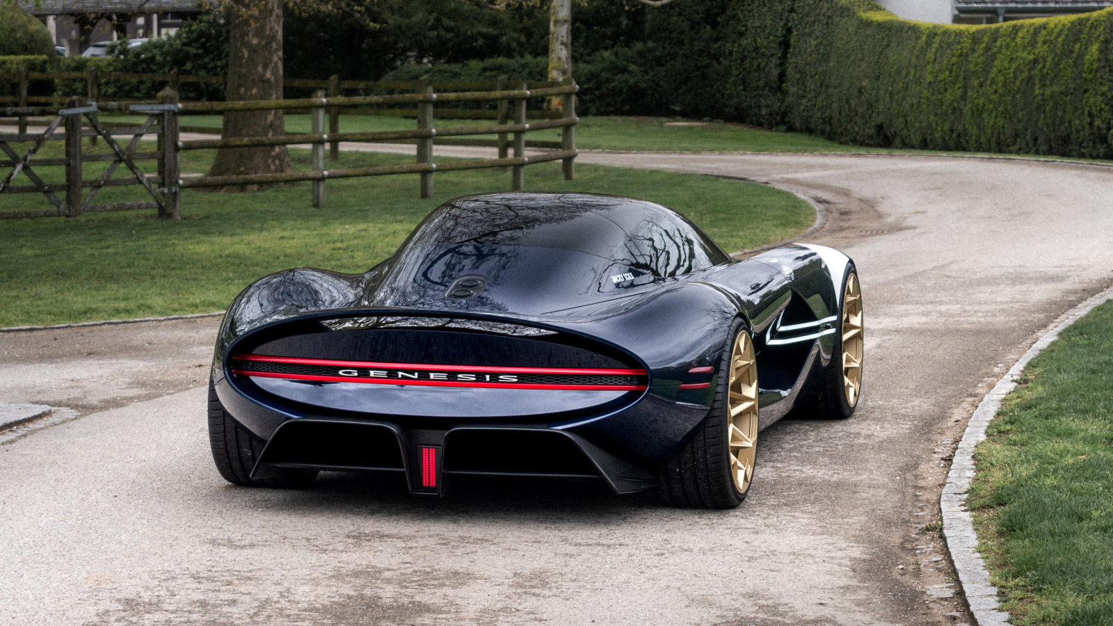 Вид сзади на черный дорогой автомобиль Genesis X Gran Berlinetta Tribute 2024  года