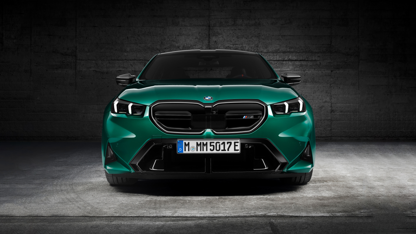 Зеленый автомобиль BMW M5 2024  года вид спереди